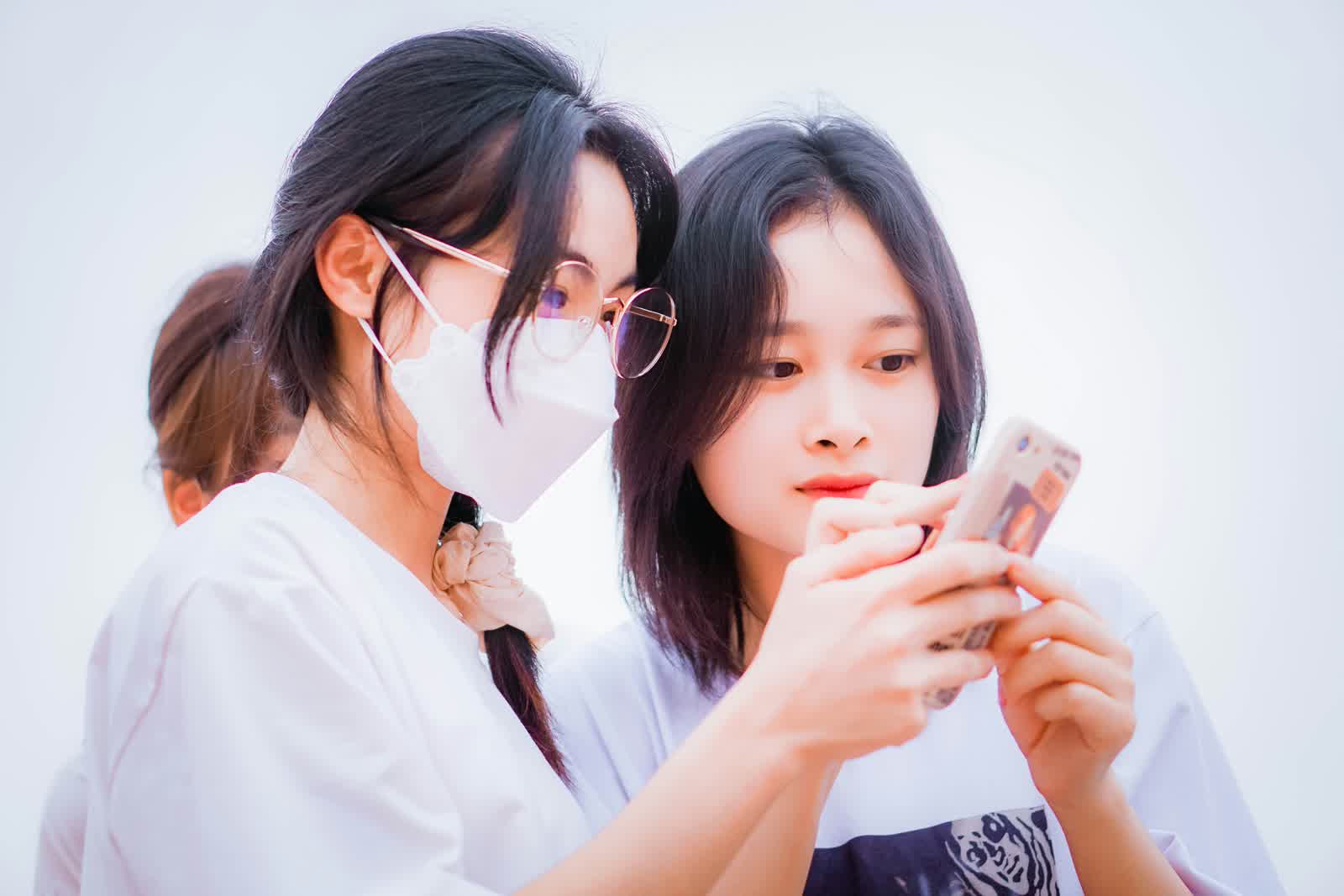 Two students looking at phone collaborating on lesson